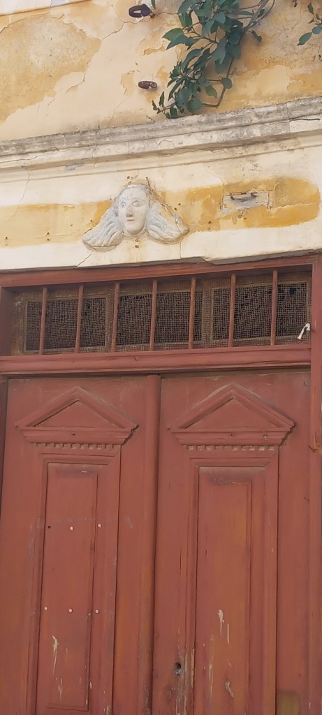 Talking of details, which we weren’t, here’s a detail from above a door in the village. Any idea where? 